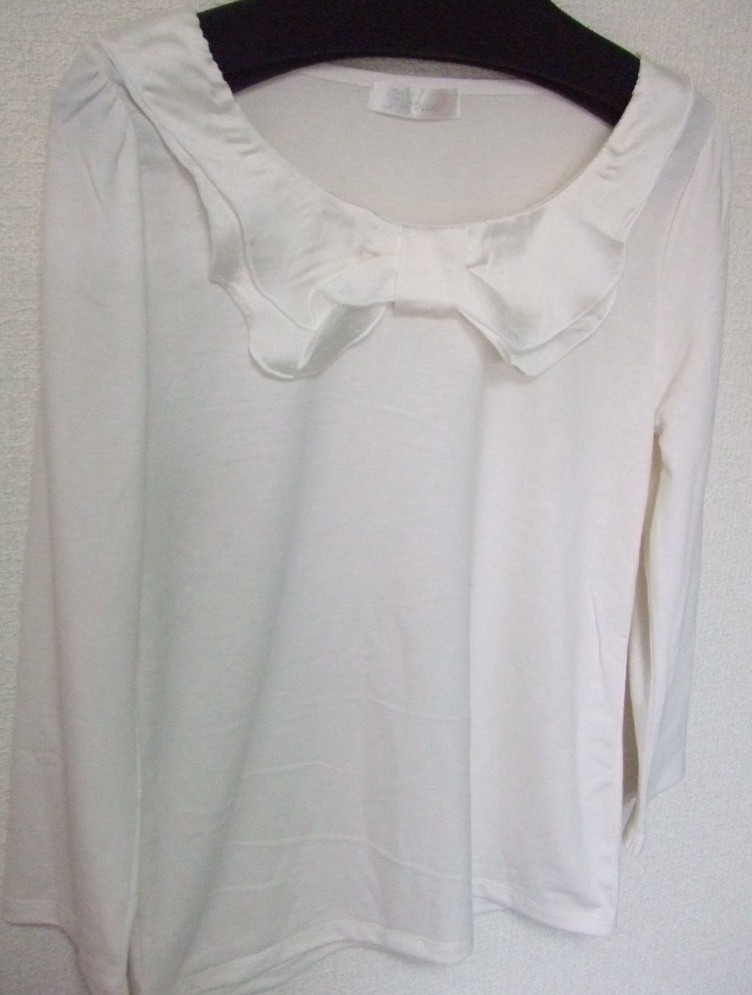 ⑤白のカットソー 七分袖で、胸元がリボンぽいデザイン